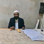 Man recreating tiles to replace the old ones in the mosque. Slow, precise work.