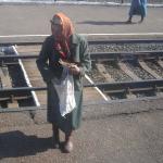 Babushka selling goods on the train platform.